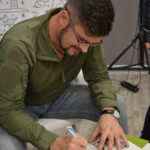 Michał Gołkowski podpisuje autograf na książce "Ołowiany świt"