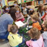 Bibliotekarka głośno czyta, dzieci słuchają