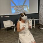 Następna bibliotekarka używa z gogli VR i kontrolerów pilotuje samolot